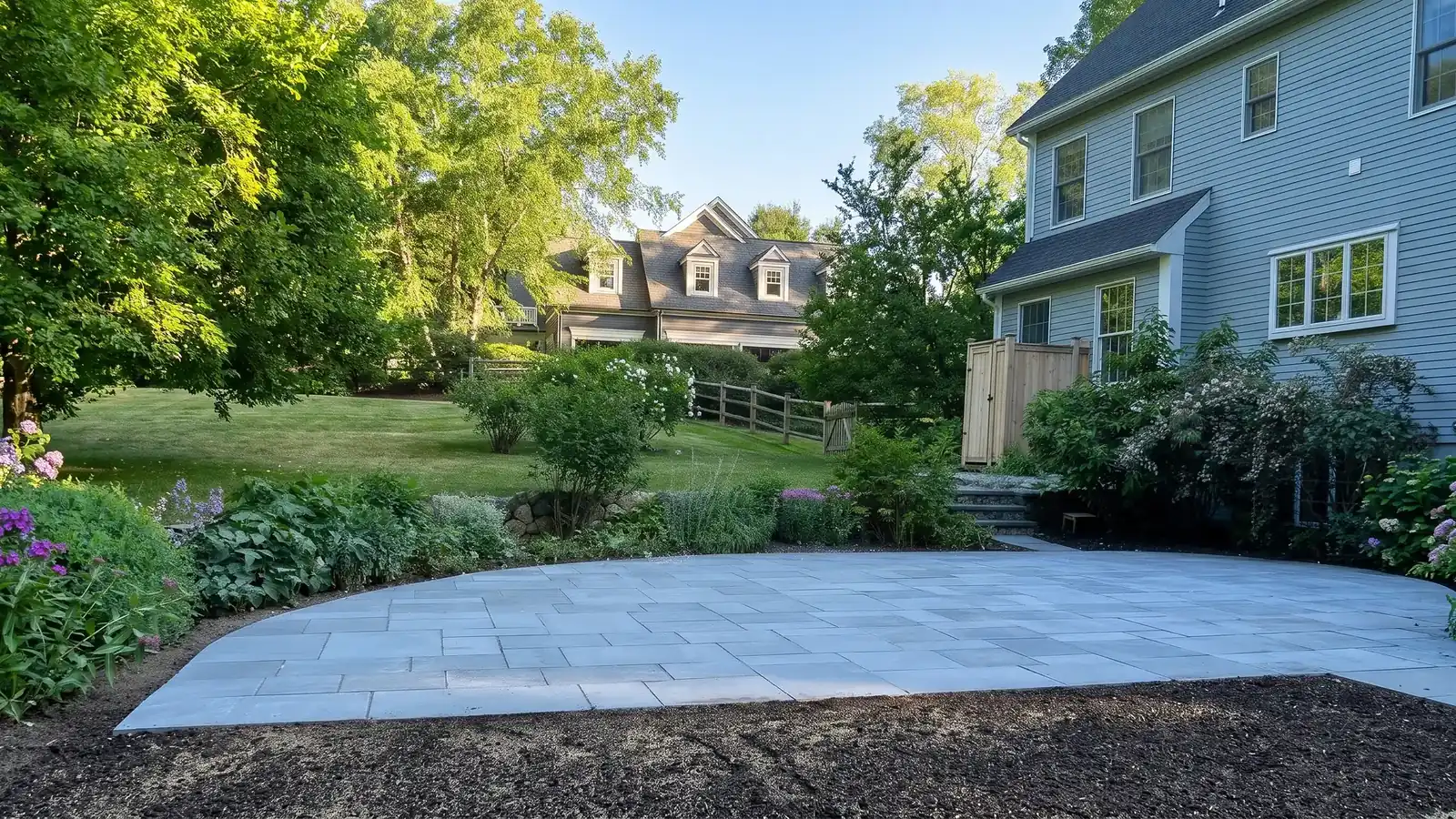 Bluestone patio meeting the garden beds behind a colonial home